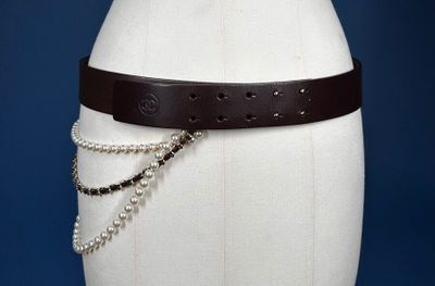 a white mannequin torso with a brown belt on it