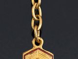 a gold necklace with a red rose on it