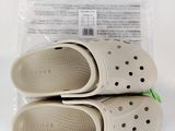 deux paires de Crocs se trouvent dans un sac en plastique posé sur une table