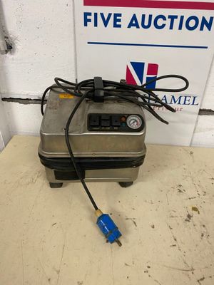 a close up of a machine on a table with a sign in the background