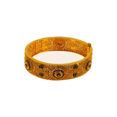 gros plan d'un bracelet en or sur fond blanc
