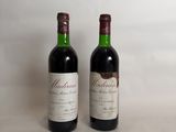 two bottles of wine sitting next to each other on a table