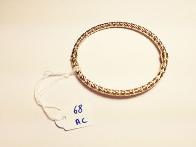 a close up of a gold bracelet with a tag on it