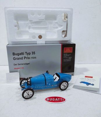 une petite voiture bleue posée à côté d'une boîte blanche