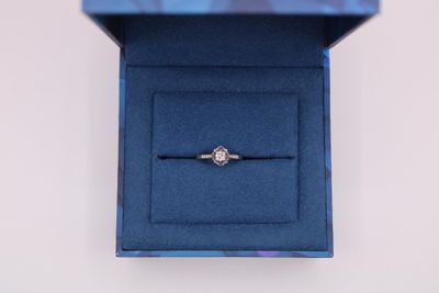 un gros plan d'une bague dans une boîte bleue posée sur une table