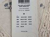 the label on the top of a white dress is attached to a hanger