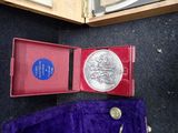 a silver coin in a red box on the floor