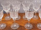 six clear wine glasses sitting on top of a wooden table