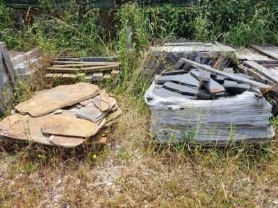 un tas de bois posé dans l'herbe à côté d'un tas de bûches
