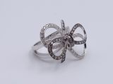 a close up of a ring with a bow on top of it