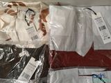 three shirts that are wrapped in plastic bags on a table