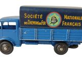un petit camion jouet bleu avec une pancarte à l'arrière