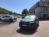 une voiture noire garée devant un bâtiment dans un parking