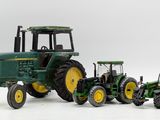 four toy tractors that are sitting next to each other