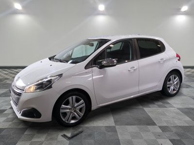 la voiture blanche est garée sur un sol en damier dans le garage