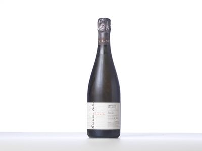 une bouteille de vin posée sur une table blanche