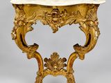 an ornately carved console table with marble top