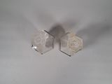two white hexagons sitting on a white surface