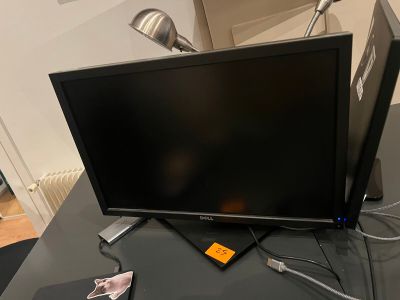 a flat screen tv sitting on top of a desk next to a laptop