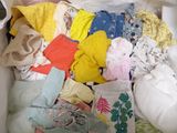 a white box filled with lots of clothes and a cell phone