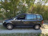 a black van parked on a dirt road near trees