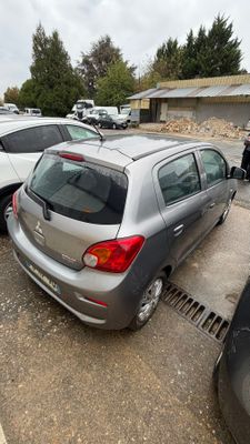 plusieurs voitures garées sur un parking, avec un bâtiment en arrière-plan