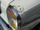 a close up of a white car with rust on it
