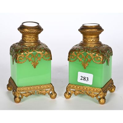 une paire de vases verts et dorés, chacun muni d'une étiquette de prix