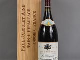la bouteille de vin est posée à côté d'une caisse en bois