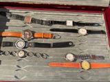 many different watches in a case on the floor