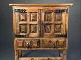 an old wooden cabinet with two doors and a shelf on top of it