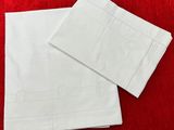 deux serviettes blanches sur une nappe rouge