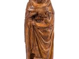 une statue en bois représentant un homme tenant un bébé dans ses bras