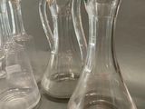 three clear glass vases sitting next to each other on a table