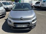 une Citroën argentée garée sur un parking à côté d'autres voitures