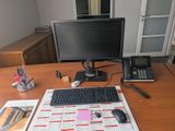 a desk with a computer, keyboard, phone, and calendar on it