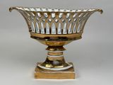 a silver and gold bowl on a stand