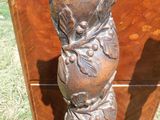 une statue représentant un homme assis sur une chaise dans l'herbe