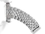 a silver watch that is being held up by a hand
