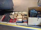 une boîte remplie de livres posée sur un tapis roulant