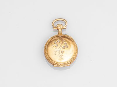 une vieille montre de poche en or avec une chaîne, posée sur une surface blanche