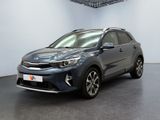 Une voiture grise est garée dans une pièce au sol noir.