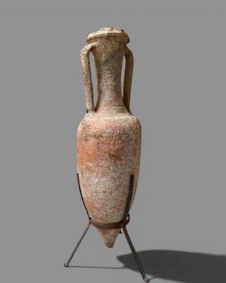 un vase en argile posé sur un socle, sur un fond gris