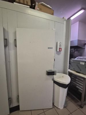 un réfrigérateur blanc et une poubelle dans une cuisine