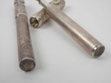 two silver colored metal objects on a white surface