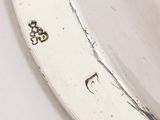 a close up of a silver plate with a clock on it
