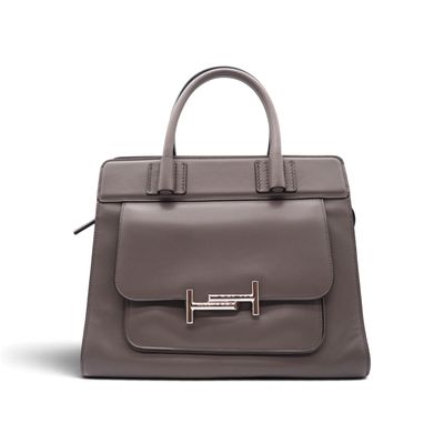 un sac à main en cuir gris muni d'une poignée métallique, sur fond blanc