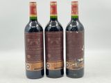 trois bouteilles de vin posées sur une table l'une à côté de l'autre