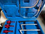 a hand holding a tool set in a blue case