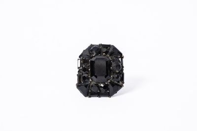 un gros plan d'une bague sertie d'un diamant noir sur une surface blanche